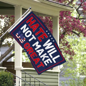 May include: A rectangular flag with the text "HATE WILL NOT MAKE US GREAT" in red and white lettering on a navy blue background. The flag includes the US flag design and white stars.