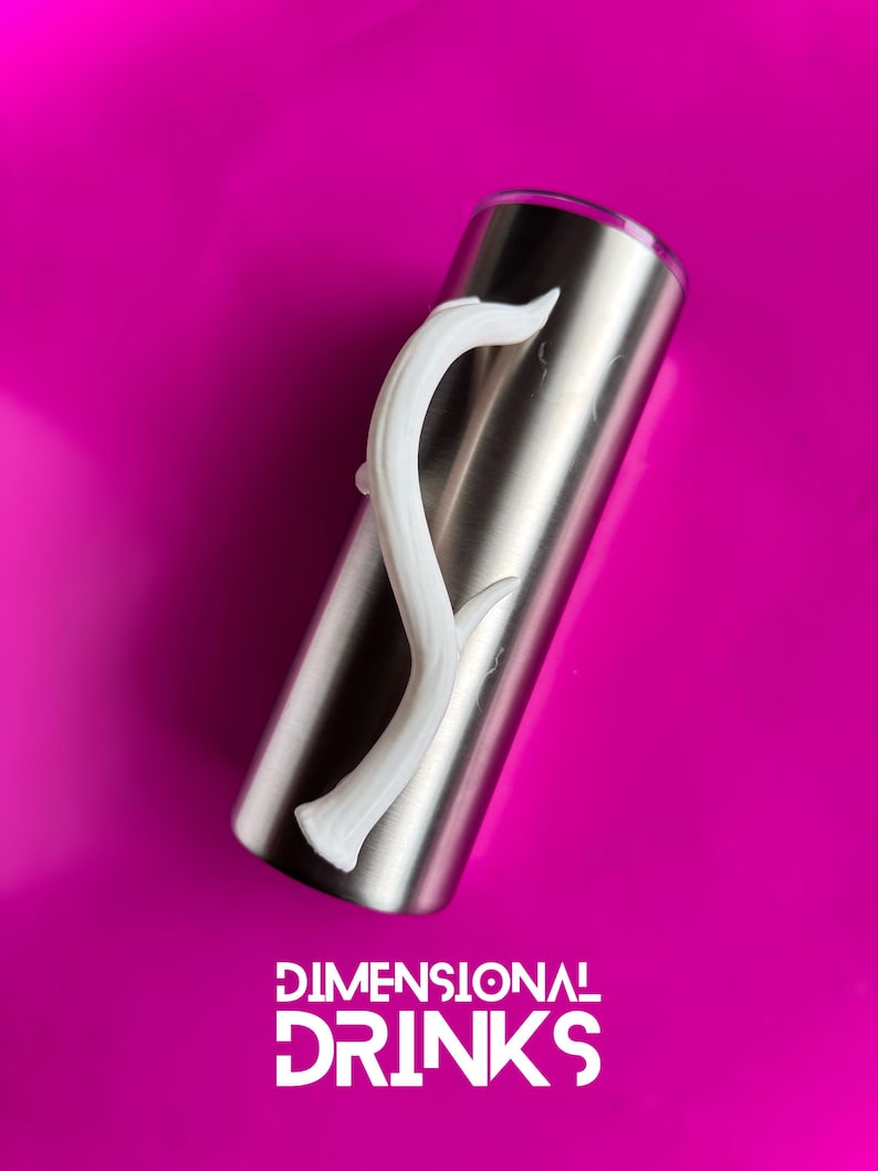 K&ouml;nnte beinhalten: Ein Edelstahlbecher mit einem wei&szlig;en, geschwungenen Griff. Der Becher befindet sich vor einem leuchtend magenta Hintergrund. Der Text "DIMENSIONAL DRINKS" ist unten im Bild in Wei&szlig; dargestellt.