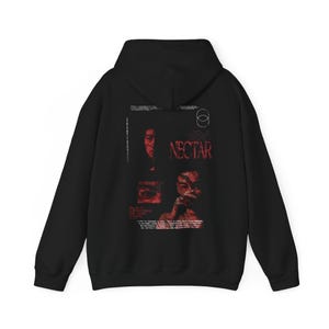 Könnte beinhalten: Schwarzer Kapuzenpullover mit einem grafischen Aufdruck eines Gesichts und dem Text "JONI NECTAR".