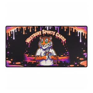 Könnte beinhalten: Rechteckige Schreibtischunterlage mit einem Tiger, der Spielkarten hält. Der schwarze Hintergrund zeigt ein Design mit tropfender Farbe in Orange, Lila und Weiß. Der Text "WESTBURY SPORTS CARDS" ist rosa.