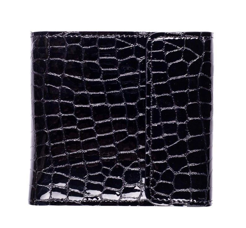 A black, glossy wallet with a crocodile skin texture. The wallet is rectangular with a flap closure on the right side. The surface reflects light, highlighting the embossed pattern.