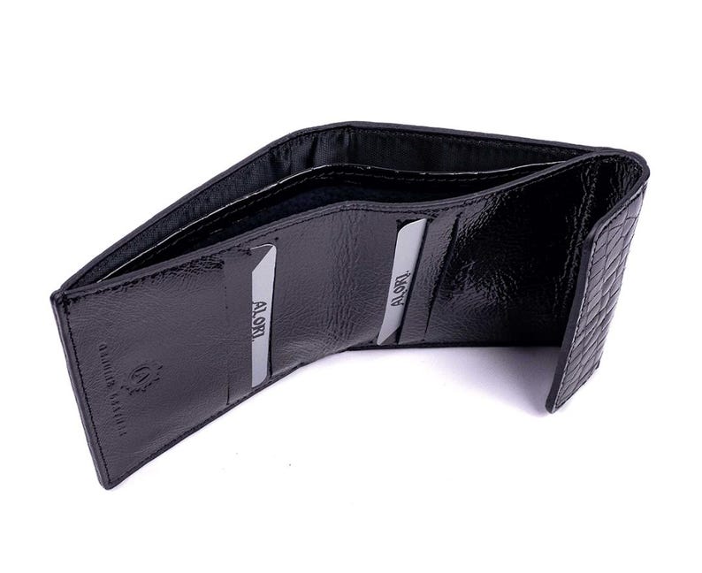 Black leather wallet with a textured exterior. The wallet is open, revealing card slots and the interior lining. The brand name is visible on the inside. The wallet is designed to hold cards and cash.