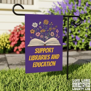 May include: Purple garden flag with a book and flowers. The text on the flag reads "Support Libraries and Education".