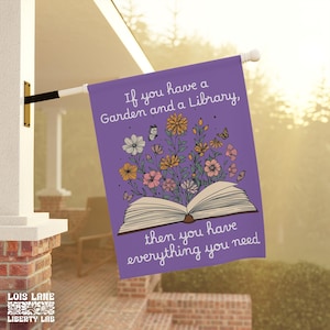 May include: A purple garden flag with the text "If you have a Garden and a Library, then you have everything you need." The flag features an open book with flowers and butterflies. The bottom left corner has the text "LOIS LANE LIBERTY LAB."
