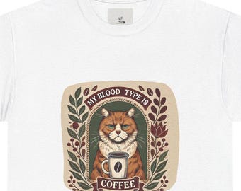 May include: White t-shirt with a graphic of a cat holding a cup of coffee. The graphic says "My blood type is coffee".