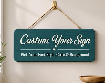 May include: A rectangular teal wooden sign hanging from a gold hook by a tan rope. The sign features the white text "Custom Your Sign" above a small heart and the text "Pick Your Font Style, Color & Background" in a clean, sans-serif font.