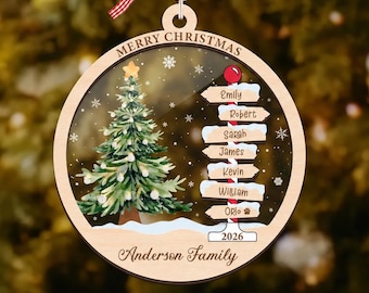 May include: A round wooden Christmas ornament featuring a printed scene of a decorated pine tree and a directional signpost with the names Emily, Robert, Sarah, James, Kevin, William, and Orlo, topped with a red and white gingham ribbon.