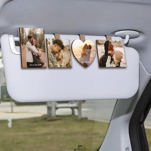 May include: Four wooden photo frames with clips, hanging from a car visor. Each frame features a different couple's photo and the text "I love you, Drive Safe".