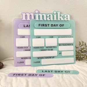 May include: A light purple and a light green acrylic sign set featuring the name maika in white 3D lettering. The signs include blank white rectangular spaces for writing details like age, height, favorite color, teacher, and future career goals.