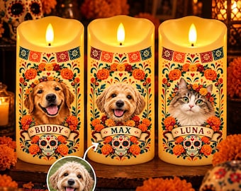 May include: Three cylindrical LED candles featuring Day of the Dead designs with marigold flowers, colorful banners, and sugar skulls. Each candle displays a pet portrait with a name banner: Buddy, Max, and Luna. A small circular inset shows the dog Max.