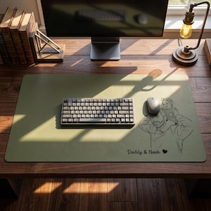 Peut inclure: Un tapis de bureau vert sauge avec un clavier, une souris et une illustration en noir et blanc d'un p&egrave;re et d'un enfant. Le texte "Daddy & Noah" est en dessous. Le tapis est sur un bureau en bois.