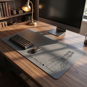 Peut inclure: Un tapis de bureau gris avec un clavier noir, une souris et un &eacute;cran d'ordinateur. Le tapis pr&eacute;sente un dessin au trait d'une personne portant un enfant, avec le texte "Happy fathers day".