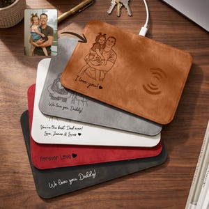 May include: A stack of five rectangular wireless charging pads in tan, gray, white, red, and black. Each pad features custom line art engravings of people and text including "I love you!", "We love you Daddy!", "You're the best Dad ever!", "Forever Love", and "We love you, Daddy!"