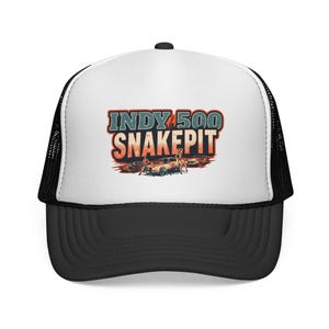 May include: Black and white trucker hat with a curved brim. The front panel displays the text "INDY 500 SNAKEPIT" in a vintage style, with an illustration of race cars. The hat has a mesh back for breathability.