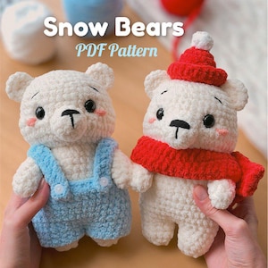 May include: Two white crochet bear dolls with black eyes and pink cheeks. One bear wears blue overalls, the other a red hat and scarf. The text "Snow Bears PDF Pattern" is displayed above the bears.