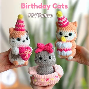 Può includere: Tre statuette di gatti all'uncinetto con cappelli da festa. Un gatto tiene in mano un cuore rosa, un altro tiene una torta e il terzo è seduto in un cestino rosa. Il testo "Birthday Cats PDF Pattern" è in alto.