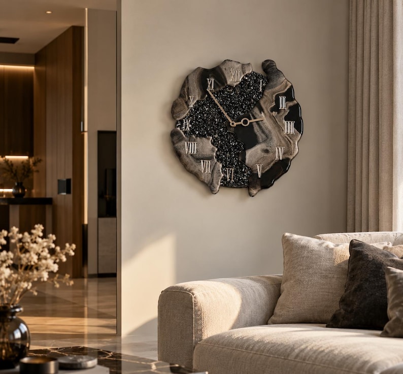 May include: A wall clock with an irregular, organic shape featuring a black and gray marbled border. The center is filled with black, textured, glittery material. It has gold-colored hands and silver Roman numerals applied to the surface.