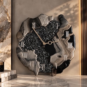 May include: A wall clock with an irregular, organic shape featuring a black and silver marbled resin border. The center contains a textured, dark crystalline surface with silver Roman numerals and thin, gold-colored metal clock hands.