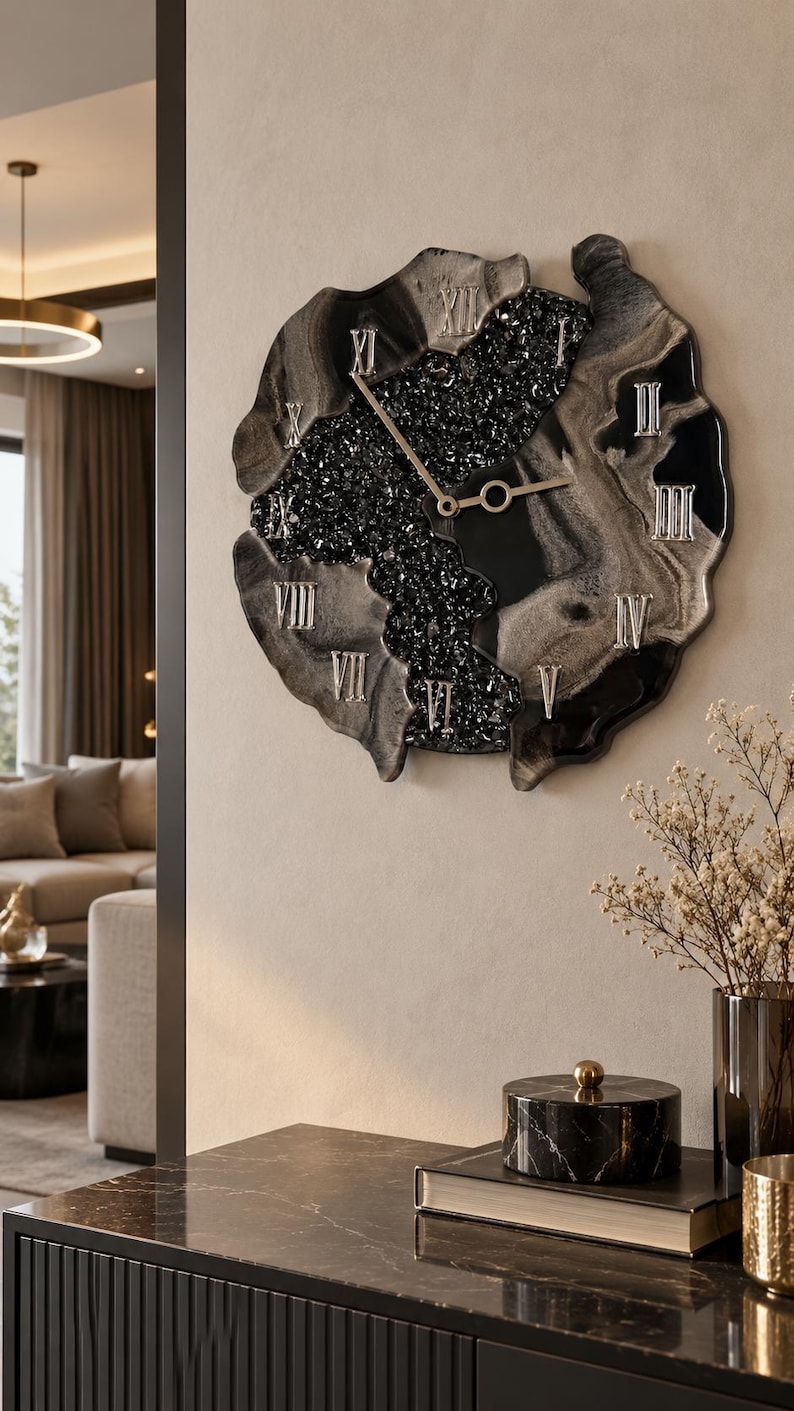 May include: A wall clock with an irregular, organic shape featuring a black and silver marbled resin finish. The center contains a textured black crystalline inlay. It displays silver Roman numerals and thin, gold-toned metal clock hands.