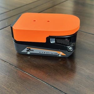 May include: An orange and black power tool battery with the text "2Ah LITHIUM 18V" printed on the side.