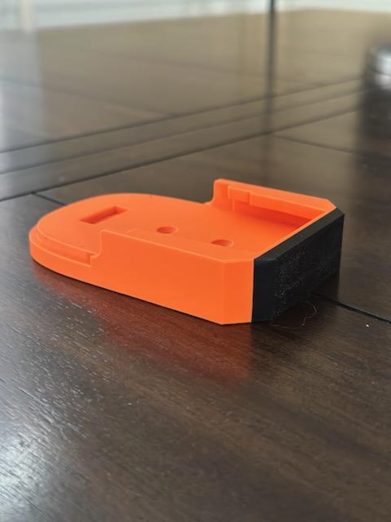 May include: Orange and black 3D printed battery holder.