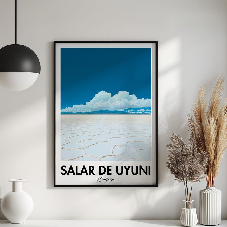 Op de afbeelding: Een zwart ingelijste poster met een foto van de Salar de Uyuni zoutvlakte in Bolivia. De foto toont een uitgestrekte witte zoutvlakte met een blauwe lucht en witte wolken erboven. De tekst "Salar de Uyuni, Bolivia" staat onderaan de poster gedrukt.