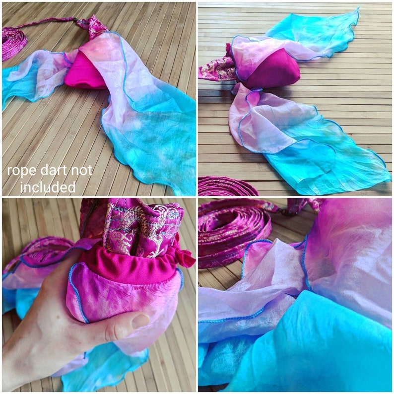 May include: A magenta fabric pouch featuring a gold dragon pattern, attached to long, flowing silk streamers that transition from light purple to bright turquoise. The edges of the streamers are finished with a thin, dark blue rolled hem.