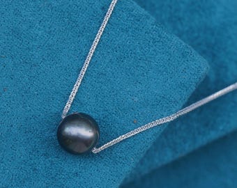 May include: A silver chain necklace with a single black pearl pendant.