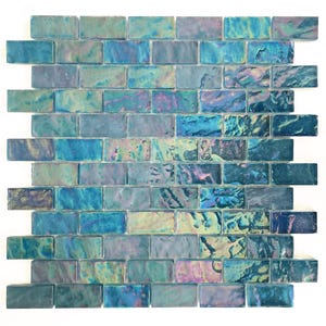 May include: A sheet of iridescent blue glass mosaic tiles in a brick pattern. The tiles are small and rectangular, with a slightly textured surface.