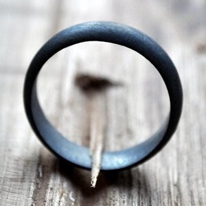 May include: A black ring with a smooth, matte finish. The ring is made of a durable material and has a simple, classic design.