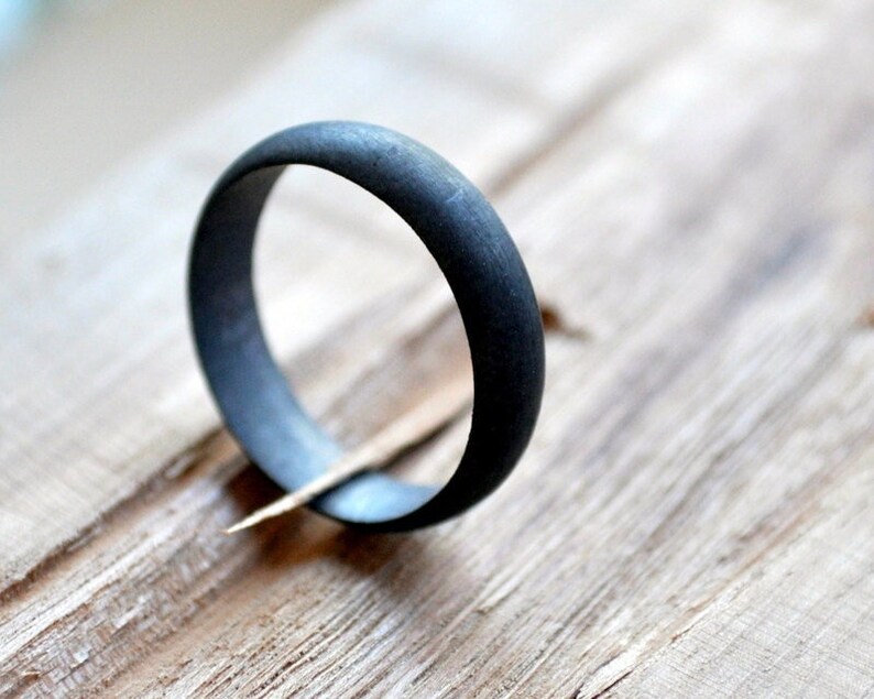 May include: A simple black ring with a smooth, matte finish.