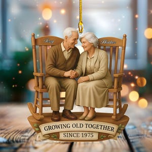 May include: A brown ornament depicting an elderly couple in rocking chairs, holding hands. The chairs are labelled "Terry" and "Heather". The text "Growing Old Together Since 1975" is on a banner below the couple, ideal for a Christmas tree.