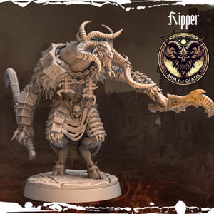 May include: A detailed miniature figurine of a horned, goat-like creature with a skull pendant and a weapon. The figurine is painted in a light brown color and is standing on a round base. The figurine is labeled "Kipper" and "Army of Chaos".
