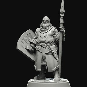 Puede incluir: Una miniatura gris detallada de un caballero medieval, con casco, cota de malla y un abrigo largo. El caballero sostiene una lanza y un escudo. El escudo tiene una textura de madera. Una espada está sujeta al cinturón del caballero.