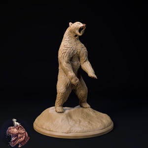 以下が含まれることがあります： 口を開けた直立したクマの精巧な彫刻で、歯が見えています。 クマは薄茶色で、小さく丸いタン色の台座の上に立っています。 背景は黒です。 恐竜に乗った犬の小さな画像が左下にあります。