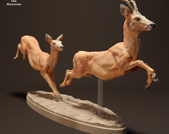 May include: Two leaping deer figurines, crafted with detailed realism. The deer are a light brown color, with delicate antlers on one. They are mounted on a beige oval base with a textured surface, suggesting a natural setting. The text "Animal Den Miniatures" is in the upper left corner.