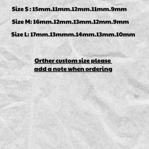 May include: A light beige background with text in a cursive font that reads "Nail size". Below the title are size measurements in millimeters for XS, S, M, and L nail sizes. Additional text requests custom sizes.
