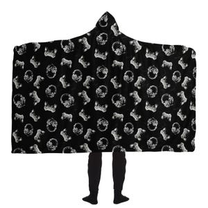May include: Black hooded blanket with a white repeated pattern of video game controllers and headphones.