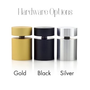Op de afbeelding: Drie metalen displaystandaards in goud, zwart en zilver. Hardware-opties.