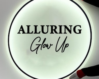 May include: A round, illuminated sign with the words "ALLURING Glow Up" in black lettering. The sign has a black border and is held by gloved hands. The sign emits a soft, white light, creating a clean and modern aesthetic.