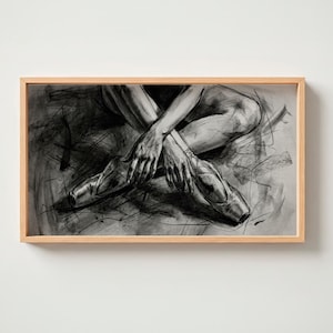 Puede incluir: Dibujo a carboncillo enmarcado de una bailarina de ballet. La obra representa las piernas y los brazos cruzados de la bailarina, con zapatillas de punta. El dibujo está en tonos grises y negros, con trazos de lápiz y sombreado visibles, creando un efecto texturizado.