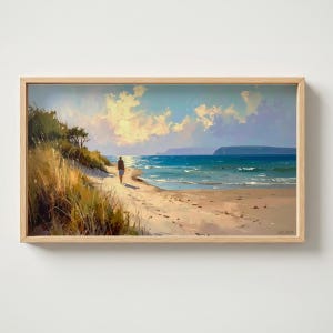 Puede incluir: Pintura enmarcada de una escena de playa. Una persona camina por la orilla arenosa hacia el mar. El cielo es azul con nubes blancas y esponjosas. La pintura está en un marco de madera clara.