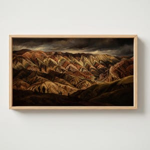 Puede incluir: Pintura enmarcada de un paisaje montañoso con formaciones rocosas en capas en tonos marrones, rojos y amarillos. El cielo es oscuro y tormentoso. Varias figuras pequeñas son visibles al pie de las montañas.
