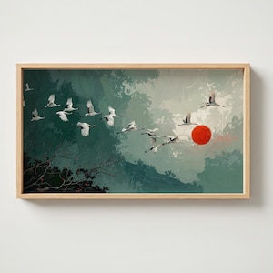 Puede incluir: Una impresión artística enmarcada que representa una bandada de pájaros blancos en vuelo sobre un fondo de montañas verdes y grises. Un sol rojo es visible en la distancia. La obra de arte está en un marco de madera.