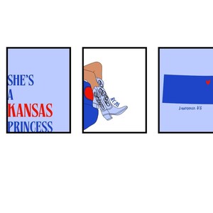 Op de afbeelding: Drie ingelijste kunstprints met een Kansas-thema. Eén print leest "SHE'S A KANSAS PRINCESS" in blauw en rood. Een andere toont de benen van een persoon en cowboylaarzen. De derde toont de omtrek van Kansas met een hart.