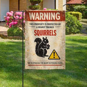 May include: A garden flag with a distressed, vintage look. The flag features the word "WARNING" in red, with the text "THIS PROPERTY IS PROTECTED BY A HIGHLY TRAINED SQUIRRELS." A black squirrel holding a nut is also shown. The bottom reads "NOT RESPONSIBLE FOR INJURY OR POSSIBLE DEATH."