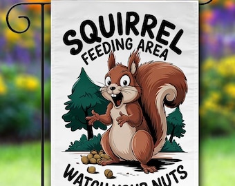May include: A white garden flag with a cartoon squirrel and the text "Squirrel Feeding Area Watch Your Nuts". The squirrel is brown and has a bushy tail. The flag is decorated with green trees and scattered acorns.