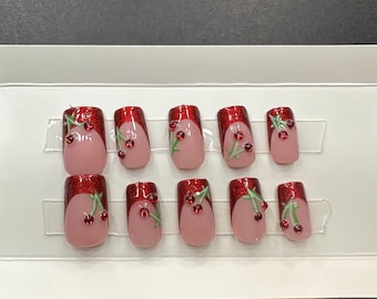 red chrome cherry nails. handmade pressons. short square with rhinestones. glossy finish. french tip.