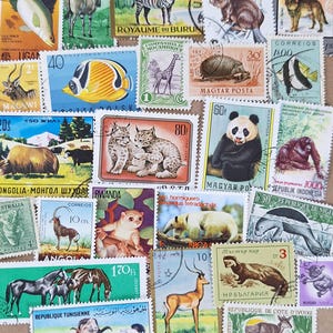 Peut inclure: Une collection de divers timbres-poste illustrés d'animaux, notamment un zèbre, un panda, une girafe, un lynx, des poissons et divers mammifères. Chaque timbre présente des illustrations uniques, des noms de pays et des valeurs numériques.