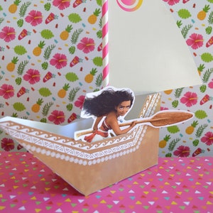 May include: A paper craft of a brown canoe with a white design. A cartoon character of a woman with long black hair is holding a wooden paddle. The canoe has a white sail with a pink and orange swirl design. A pink and white striped straw is attached to the top of the sail.